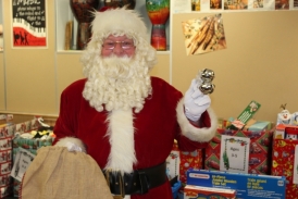 Santa Claus in front of wrapped gifts